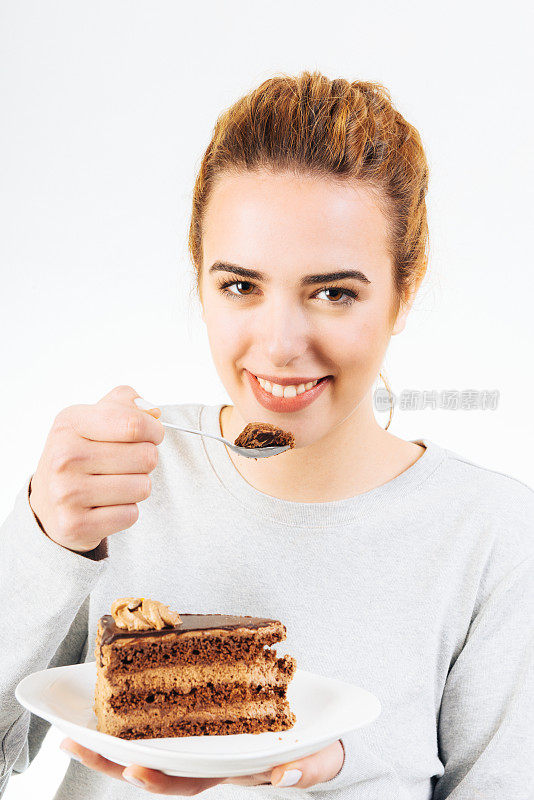 不健康的饮食-年轻的微笑女人吃美味的巧克力蛋糕