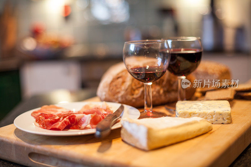 火腿，奶酪，葡萄酒和面包放在木制面包板上