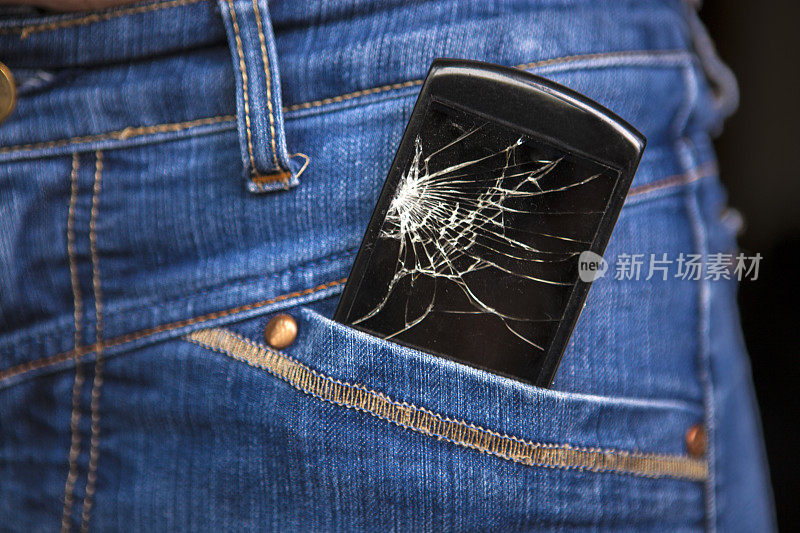 牛仔裤口袋里的破手机