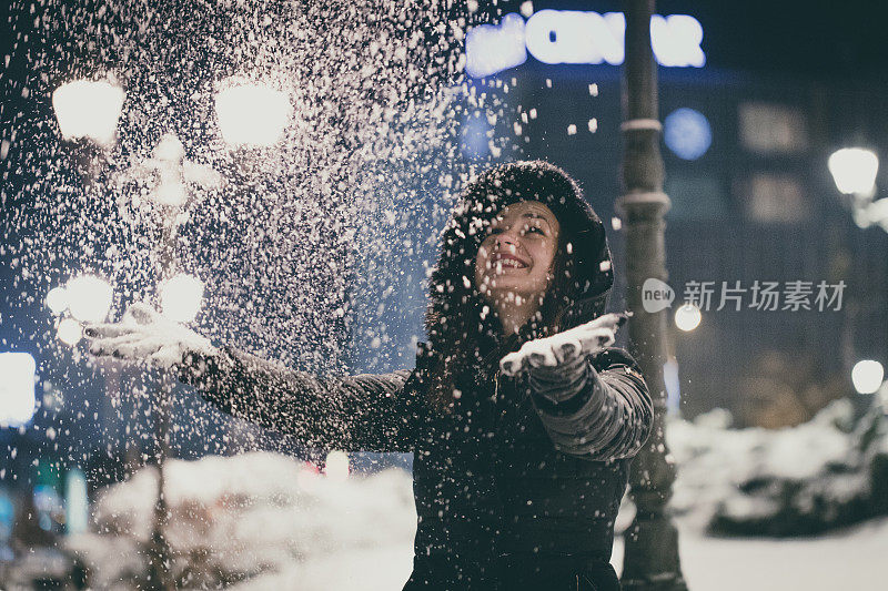 女孩在城里享受第一场雪