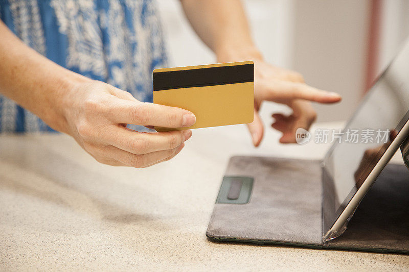 女人用信用卡网上购物，家里用数码平板电脑。