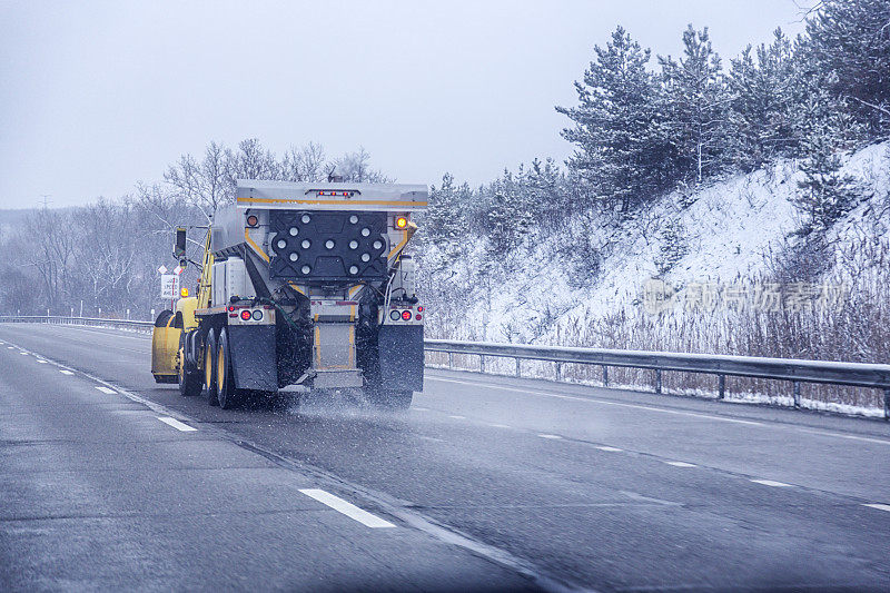 高速公路司机POV在扫雪机后面撒盐