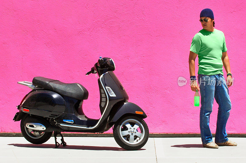 粉红墙的男人黑色滑板车绿色苏打水