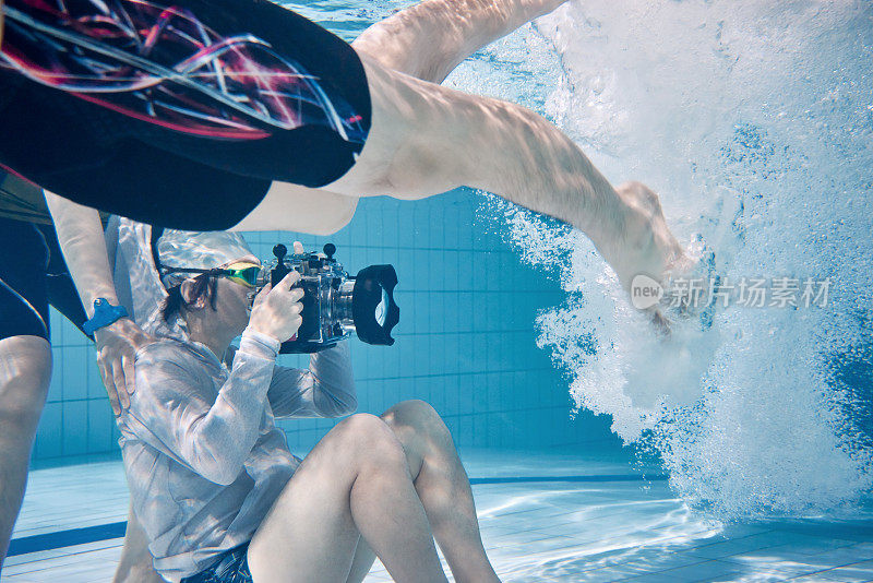 水下摄影师在游泳池中拍摄男性游泳者