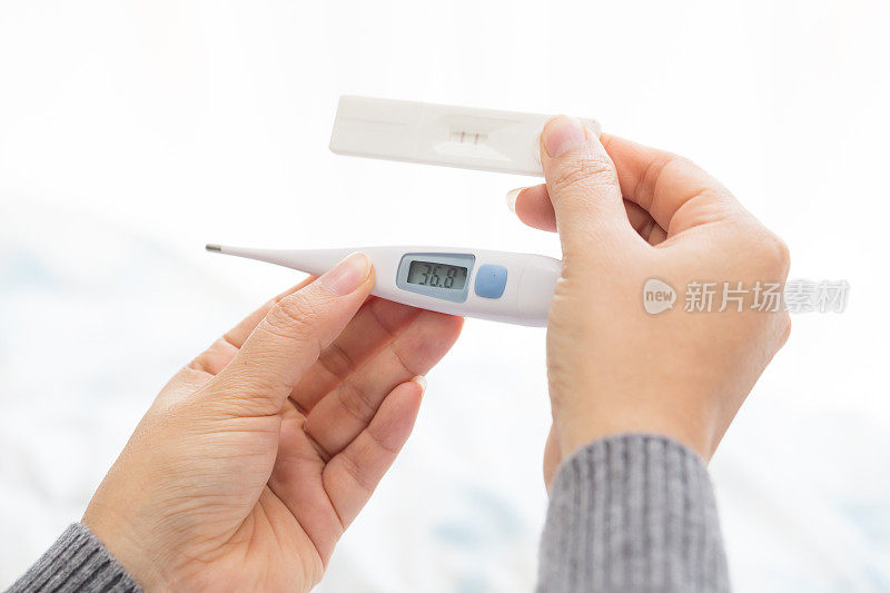 女人手握体温计和验孕