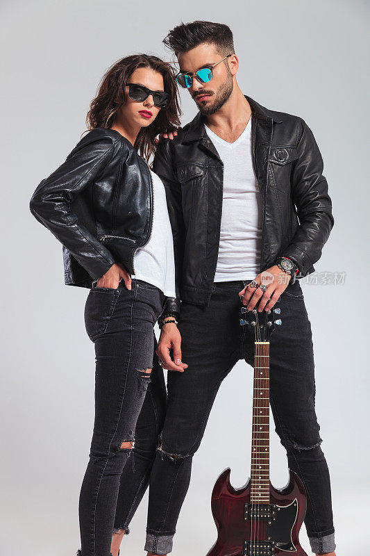 性感的夫妇穿着皮夹克拿着电吉他