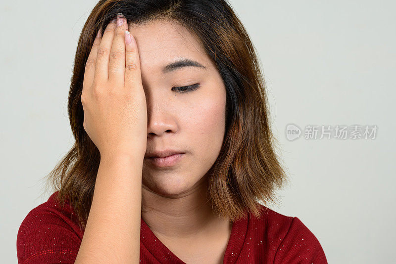 年轻的亚洲妇女穿着红色衬衫连衣裙，以白色的背景