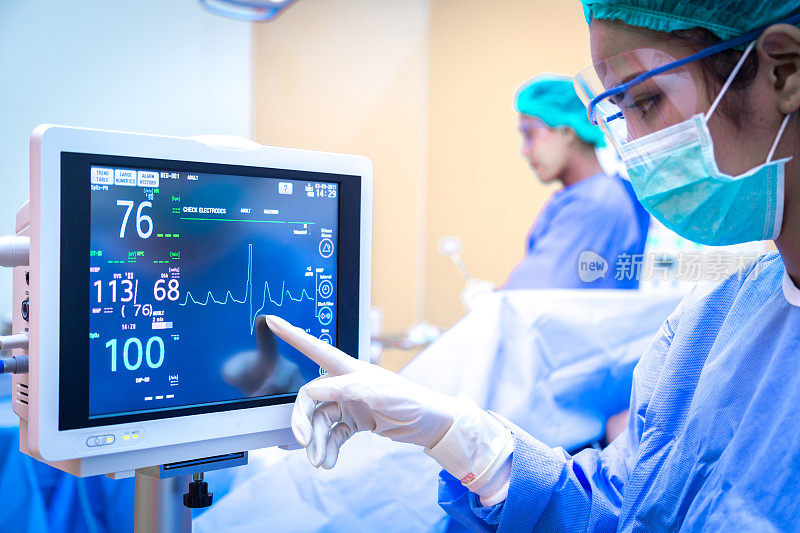 女性外科医生在手术室使用监护仪。