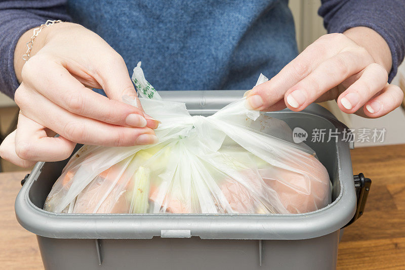 把装满食物残渣的塑料袋绑在垃圾桶里