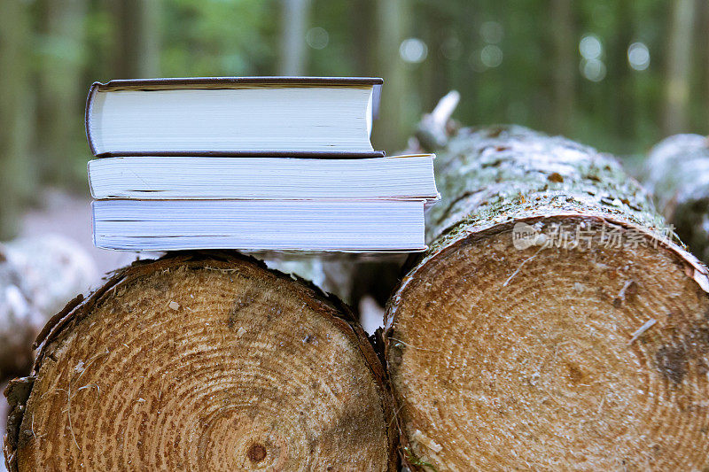 36、一堆书躺在倒下的树上，拯救树木——读电子书
