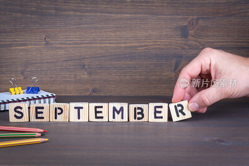 9月。木制的字母放在办公桌上，提供信息和沟通的背景