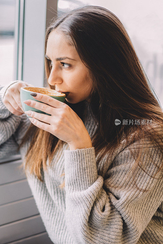近距离的肖像美丽的黑发女孩喝咖啡