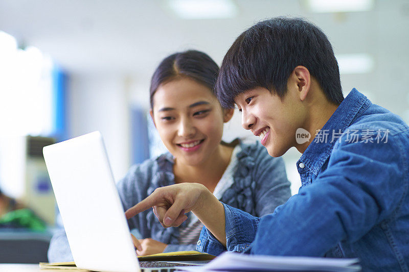 两个年轻的亚洲大学生在图书馆学习