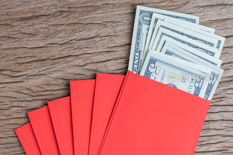 春节贺礼，传统的红色信封里装着一堆美元钞票