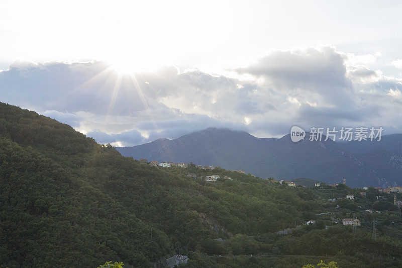 阳光透过云层照在山丘和村庄上