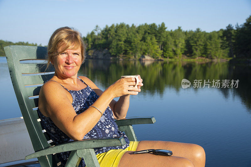 一个成熟的糖尿病女性在湖边的码头上测试她的血糖。