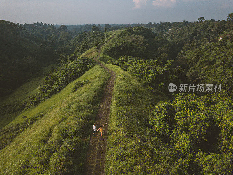 无人机的观点，年轻夫妇走在大米自然散步，乌布-巴厘岛-人们旅游热带目的地爱浪漫的概念