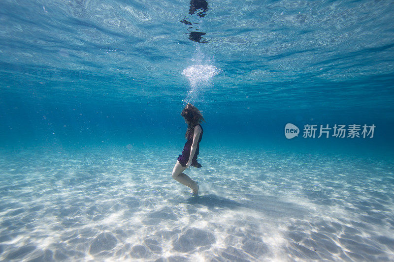 美丽的年轻女子在水里游泳