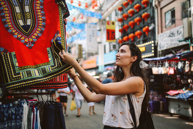 年轻的旅行者女人在吉隆坡唐人街区购物