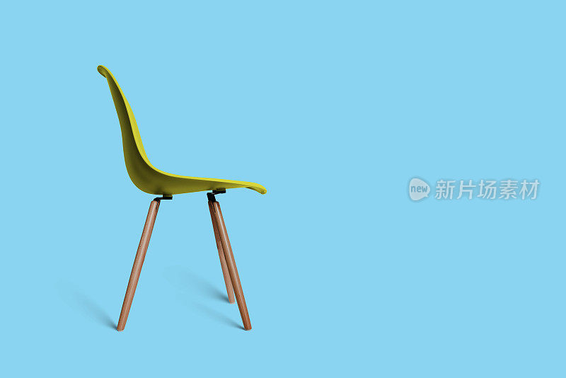 现代的黄色椅子，木腿，柔和的绿色背景