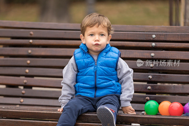 男孩在公园长凳上撅起嘴唇