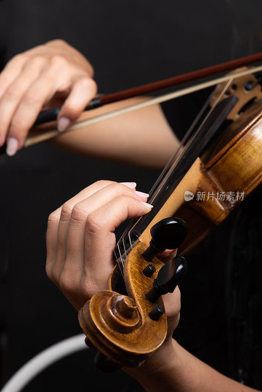 正在拉小提琴的女人双手拉着弓