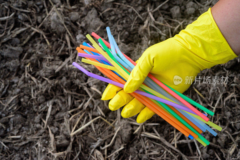 手持塑料吸管手套的手的特写——生态产业理念