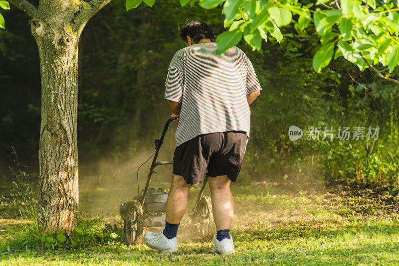 拿着割草机的人