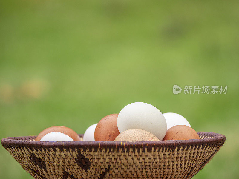 白色和棕色的鸡蛋放在编织篮子里