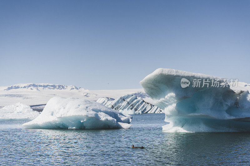 淡蓝色的冰山漂浮在平静的北冰洋上