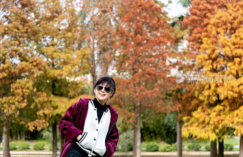 女人站在秋天的公园里
