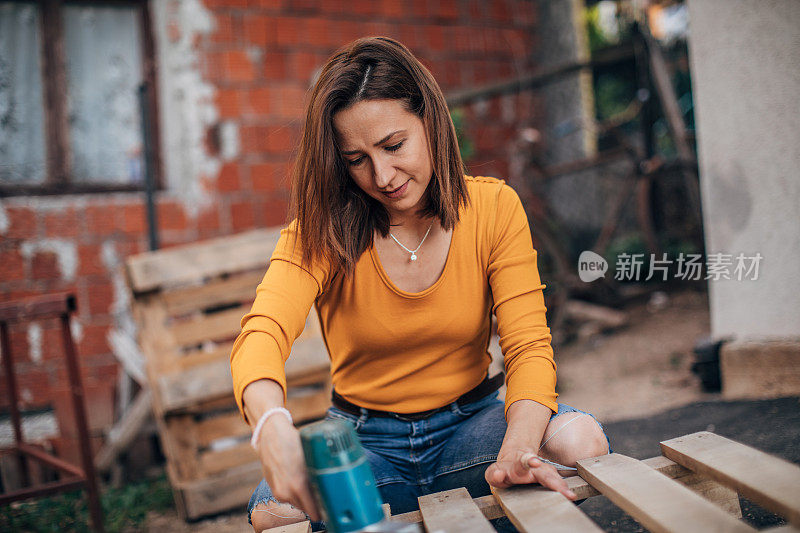 一个女人在工地上刮木板