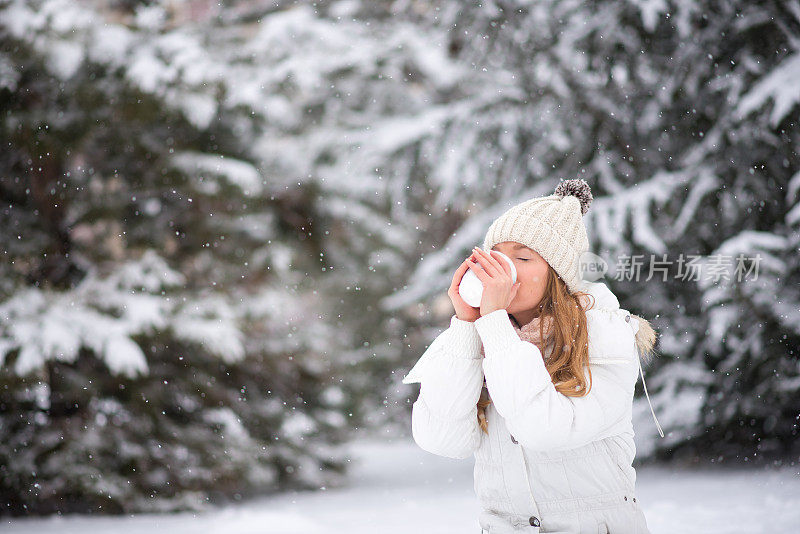 年轻女子喝着咖啡，热巧克力，茶，外面是雪
