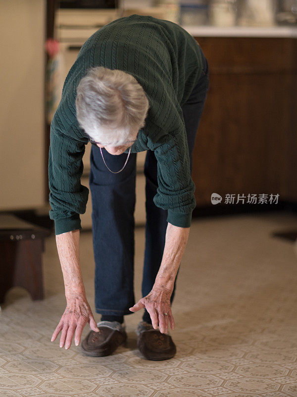 妇女弯腰触摸地板