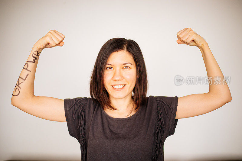 女孩的力量年轻女子展示她的手臂