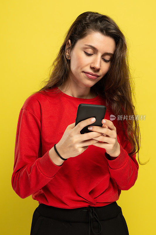 一个微笑迷人的女人使用智能手机的肖像