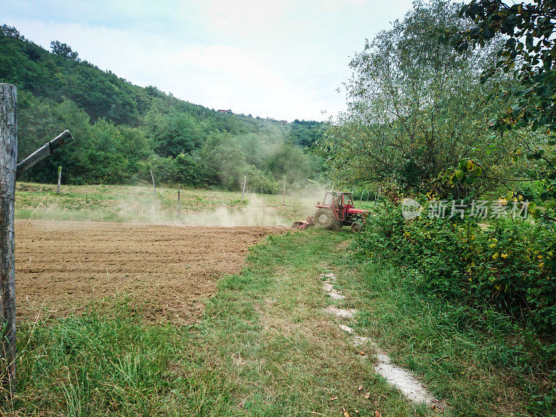 农民在用拖拉机培植旱地