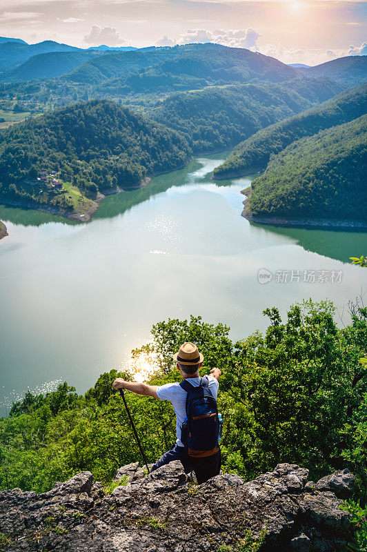 一个徒步旅行者站在山顶欣赏风景