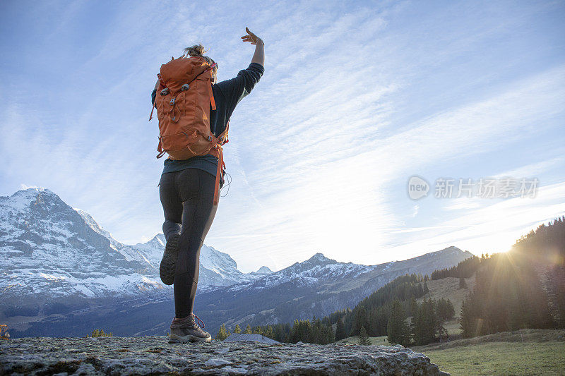 日出时分，女徒步旅行者在山脊上休息