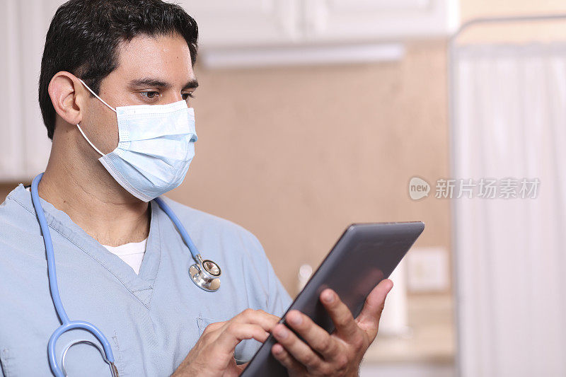 COVID-19:拉丁裔医生或护士使用数字平板电脑。