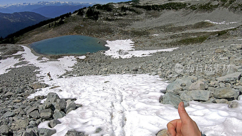 徒步旅行者沿着积雪的山坡跑下去