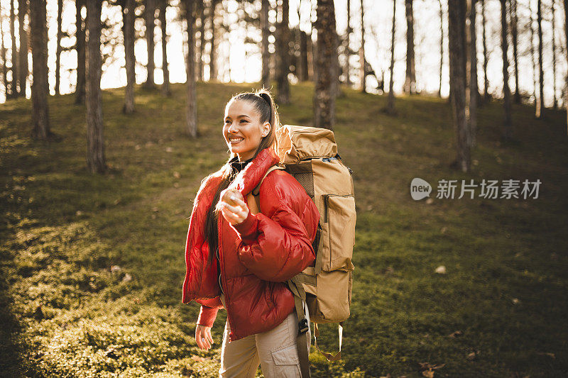 女徒步旅行者吃苹果，在日出时休息