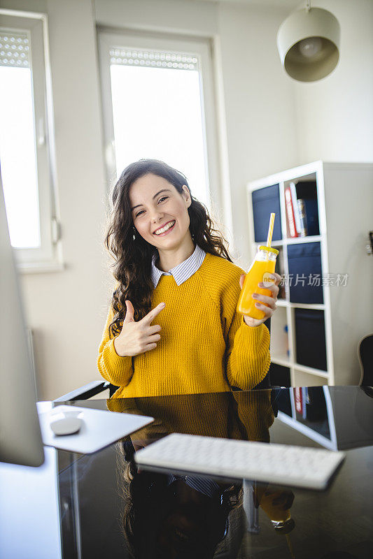 女学生在家里上网络课的时候喝着橙汁