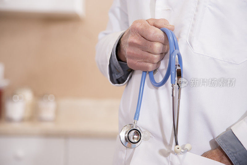 临床医生穿着实验服，手里拿着听诊器。