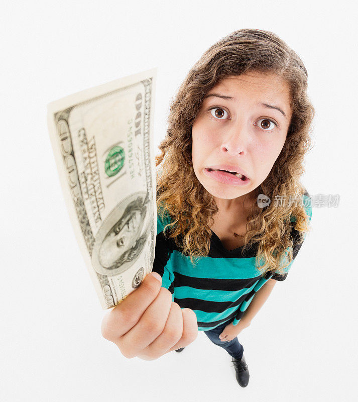 一名年轻女子手里拿着一张100美元的钞票，脸上露出沮丧的表情