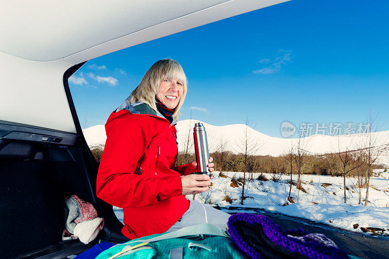 老妇人准备在苏格兰高地雪地里徒步旅行