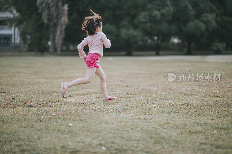 6岁的亚洲华人女孩晚上在公园里跑步