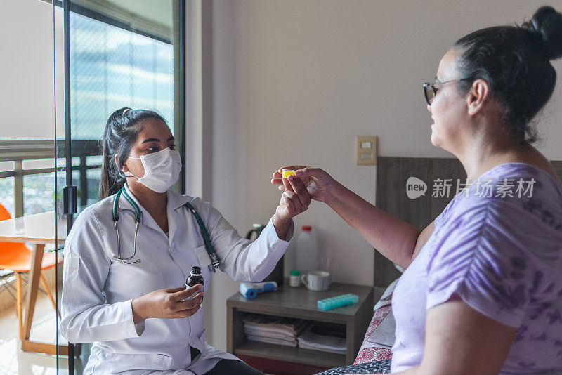 女医生把液体药物给病人在一个医疗咨询期间在家