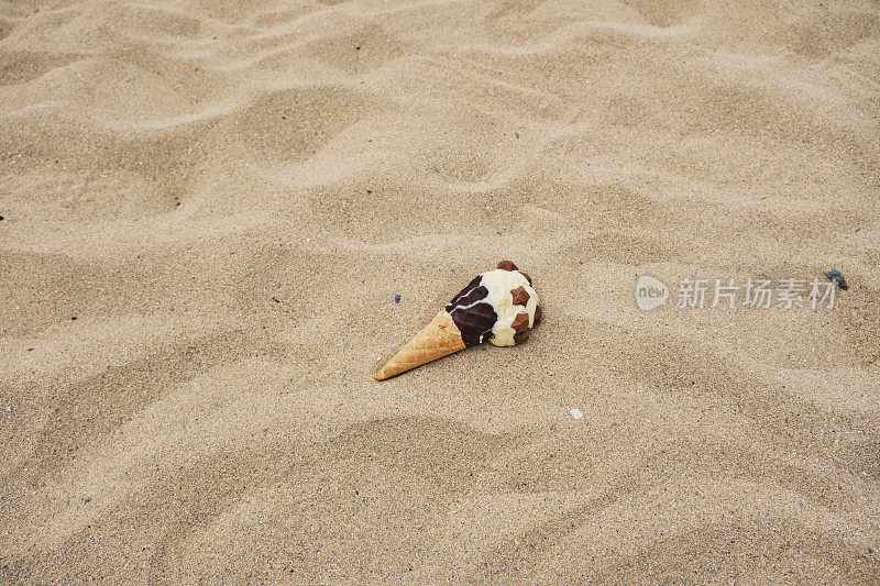 在康沃尔郡纽基的波思海滩，把冰淇淋蛋卷掉在沙滩上。