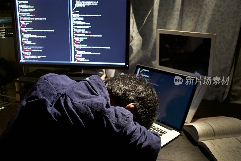 一个年轻的亚洲程序员在他的房间里编程的时候开始睡觉